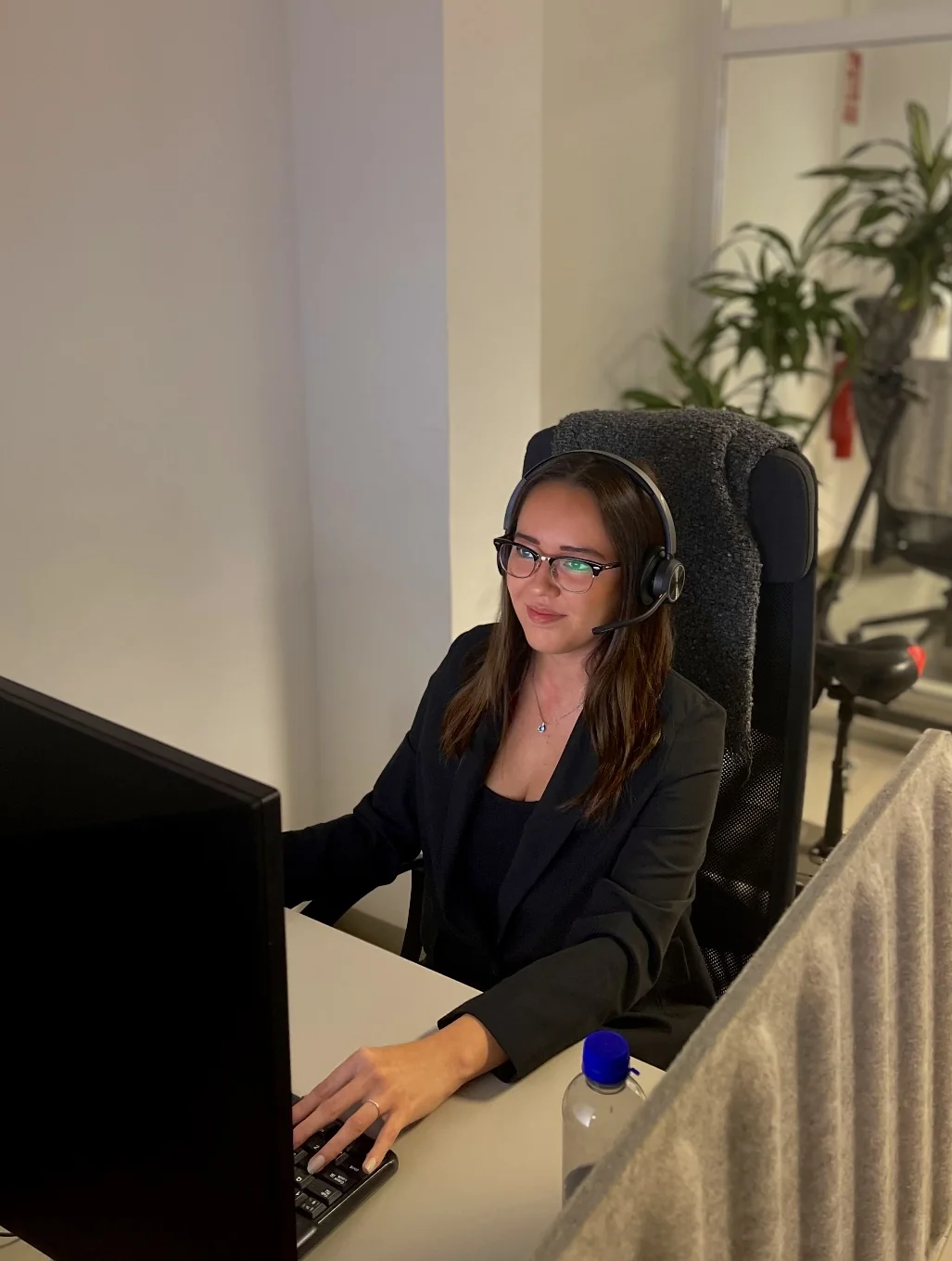 Tanja at her desk with a headset, answering a customer